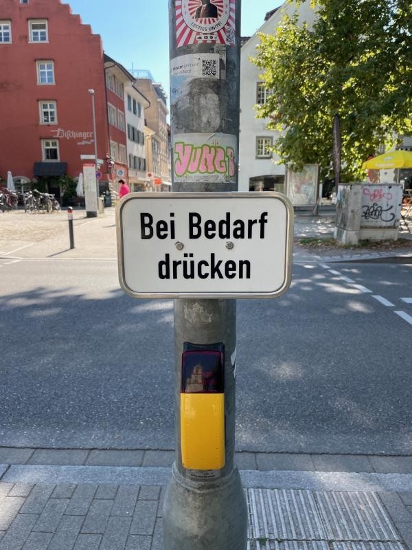 Schild "Bei Bedarf drücken" an einer Dunkelampel