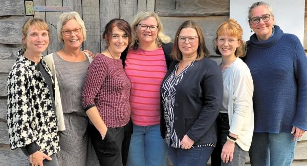 Eine Gruppe Frauen steht vor einer Wand. 