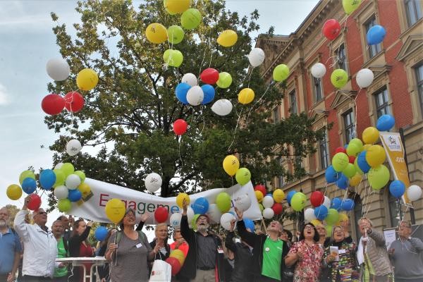 Menschen mit bunten Luftballons auf der Marktstätte