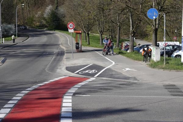 Rot markierter Verlauf eines Fahrradwegs an einer Straßenkreuzung