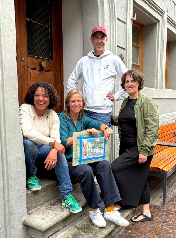 Eine Personengruppe sitzt in einem Hauseingang in der Zollernstraße